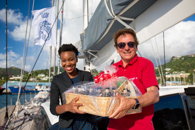 Chrislyn Lashington, Grenada Tourism Authority, presents Jean-Paul Riviere with a basket of Grenadian specialities, including Westerhall Rums, Grenadian Chocolate and Spice. Photo:RORC/Arthur Daniel