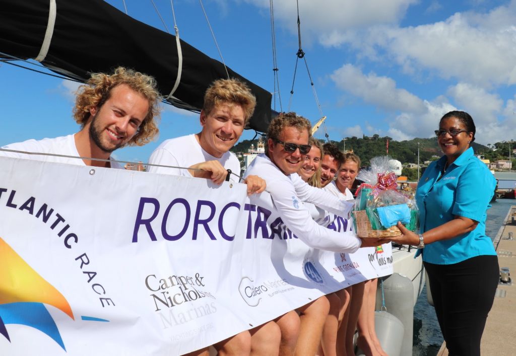    Andy Lis and the crew of Pata Negra receive a basket of Grenadian goods from Nikoyan Roberts, Grenada Tourism Authority after completing the 2019 RORC Transatlantic Race © RORC/Louay Habib